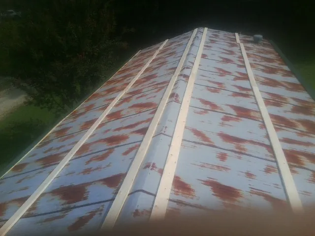 Rusted metal roof panels with new wood purlins before replacement — Storm Damage Roof Repair in Spiceland by Roofing Brothers