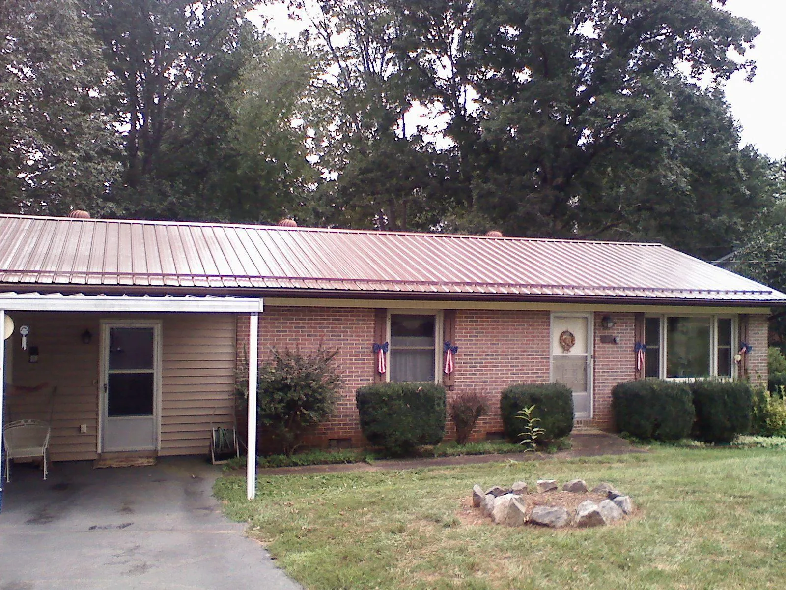 Bronze metal roof and carport on a brick ranch home — Roof Repair work by our crew in Spiceland